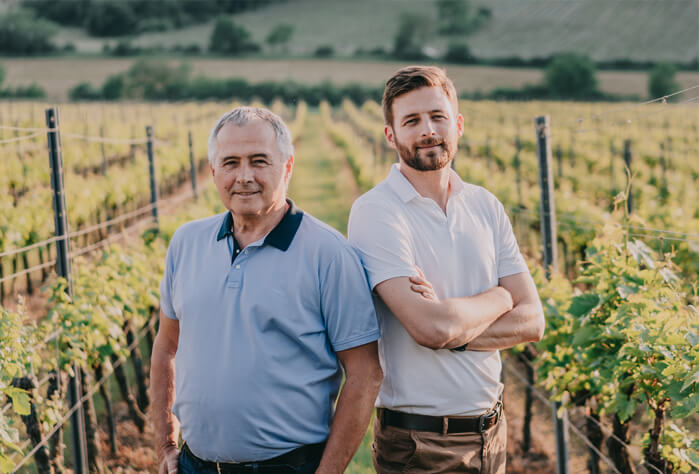 Varga Péter és Varga Máté állnak egymás mellett háttérben a szőlőültetvény